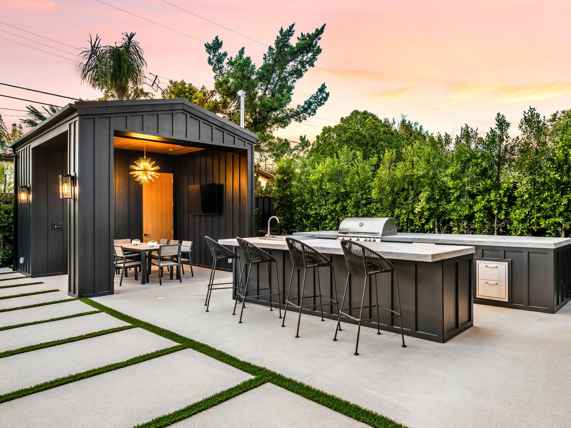 Modern outdoor kitchen and dining area at sunset